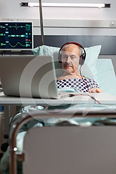 Senior sick man in hospital bed breathing through oxygen mask