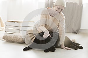 Senior sick woman stroking dog