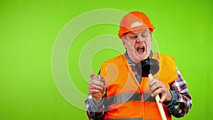 Senior smiling plumber in uniform imitating singing with plunger and having fun.