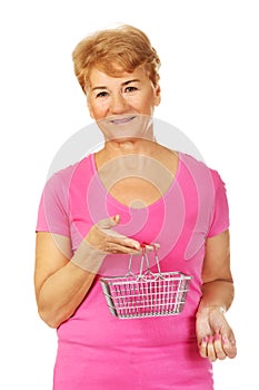 Senior smiling woman holding mini shopping basket