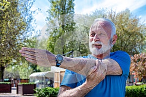 Senior sportsman stretching his arm.