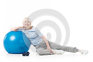 Senior sportswoman with fitness ball and dumbbells