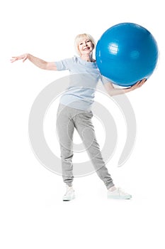 Senior sportswoman holding fitness ball in one hand