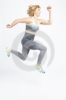 Senior Sportswoman ideas. Running Mature Sportswoman During Active Jogging Training Indoors Against White Background