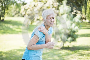 Senior sporty woman having shoulder pain