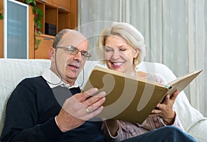 Senior spouses with picture album indoor