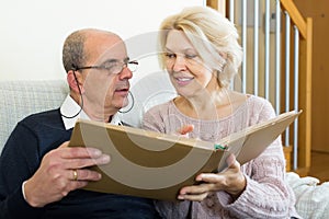 Senior spouses with picture album indoor