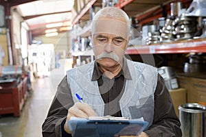 Senior stock keeper working in warehouse