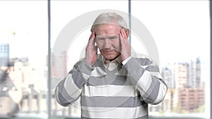 Senior stressed man suffering from headache.