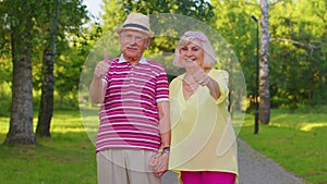 Senior stylish couple grandmother grandfather looking approvingly showing thumb up like sign gesture