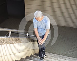 senior Suffering from knee Pain on stair