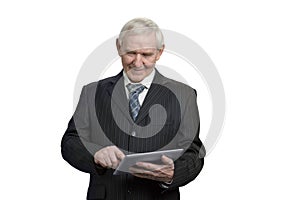 Senior in suit swiping tablet.