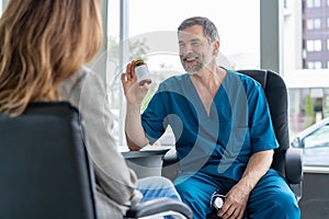 Senior surgeon consults young woman, doctor with patient in medical office.