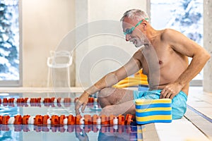 Senior swimmer in watersports goggles at the swimming pool