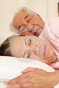 Senior Taiwanese couple sleeping