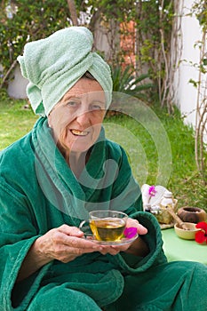 A senior takes her tisane in an open air spa studio