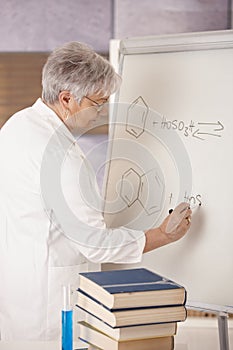 Senior teacher drawing molecular formulas