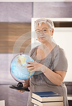 Senior teacher holding globe