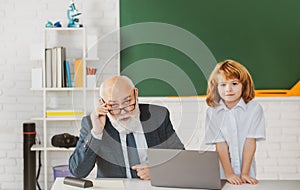 Senior teacher and pupil in classroom. Education concept. Boy elementary school. Old and Young. Grandfather and child