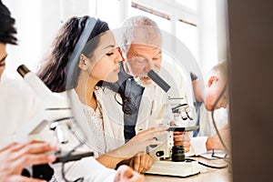 Senior teacher teaching biology to high school student in labor