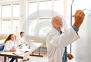 Senior teacher teaching biology to high school students in labor