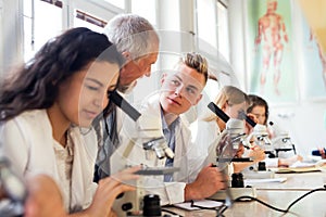 Senior teacher teaching biology to students in laboratory.