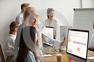 Senior team leader teaching new employee explains planning work