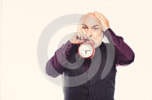 Senior timekeeper. time and age. Timekeeping. mature bearded man with alarm clock. retirement. watchmaker or watch