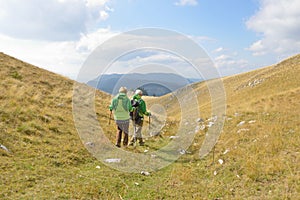 Senior tourist couple hiking at the beautiful mountains