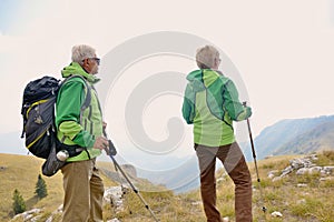 Senior tourist couple hiking at the beautiful mountains