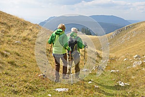 Senior tourist couple hiking at the beautiful mountains