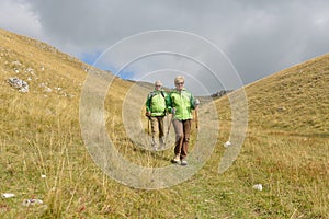 Senior tourist couple hiking at the beautiful mountains