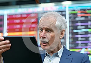 Senior trader looking shocked at his laptop.