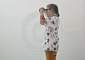 Senior traveler asian man holding binoculars