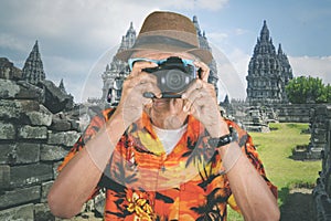 Senior traveler takes photo of Prambanan temple