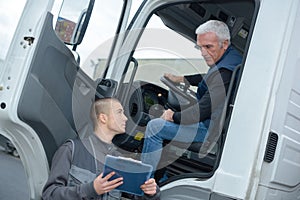 Senior truck driver taking to manager