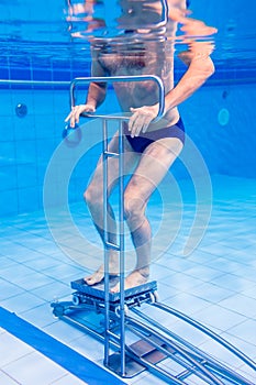 Senior in underwater gymnastics therapy