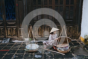 senior vietnamese woman selling food on street in Hoi An, Vietnam