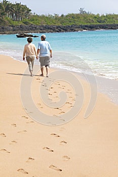 Senior walking on the beach with footprint