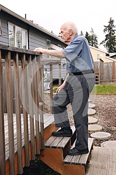 Senior walks up wooden deck steps outside