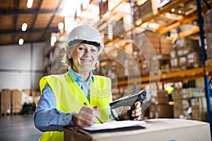 Senior warehouse woman worker with barcode scanner.