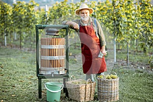 Senior winemaker with pressmachine on the vineyard