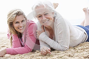 Senior Woman With Adult Daughter Relaxing On Beach