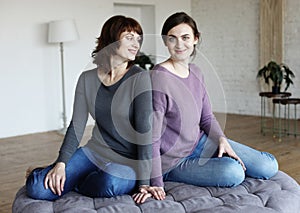 Senior Woman With Adult Daughter Relaxing On Sofa At Home