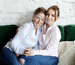 Senior Woman With Adult Daughter Relaxing On Sofa At Home