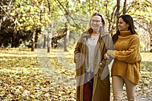 Senior woman with adult daughter walking at the park