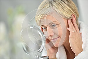 Senior woman applying anti-aging cream