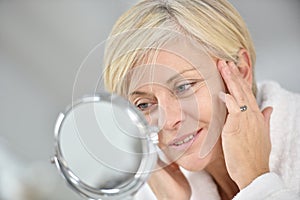 Senior woman applying anti-aging cream