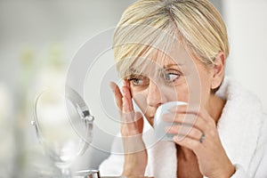 Senior woman applying anti-aging cream on her skin