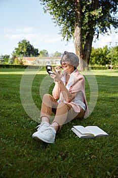 Senior woman applying lipstick doing makeup for charming smile